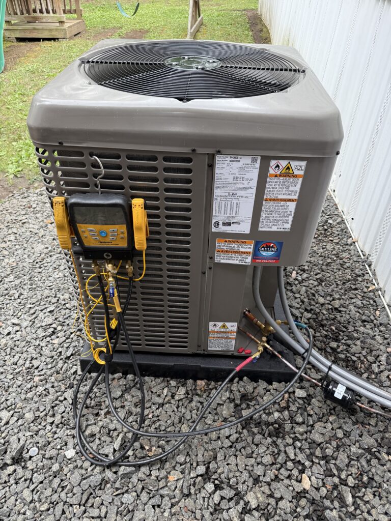 Digital manifold gauges connected to a heat pump during start-up in Raleigh, NC.